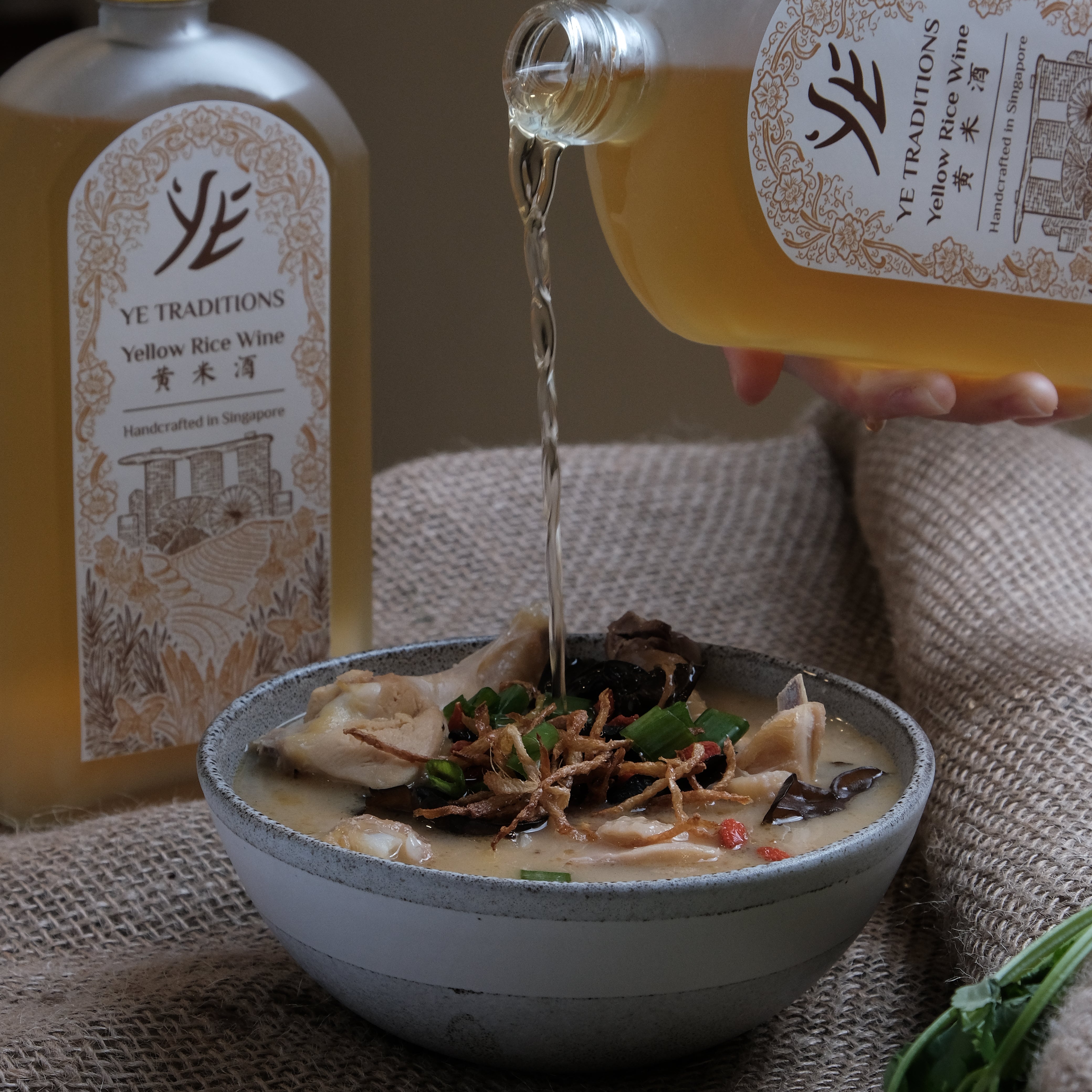 Bowl of soup with a bottle of 'YE Traditions' Yellow Rice Wine