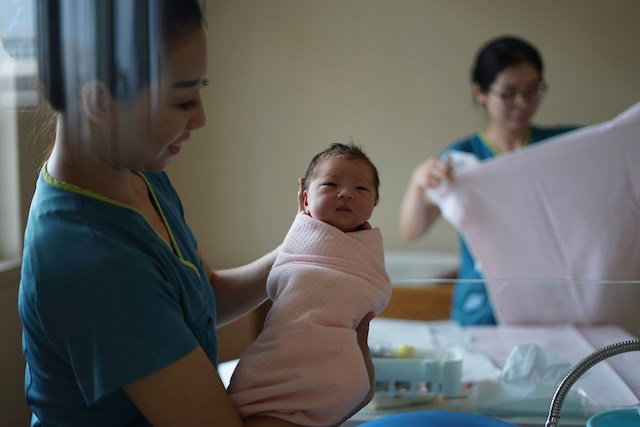 nurse carrying new baby
